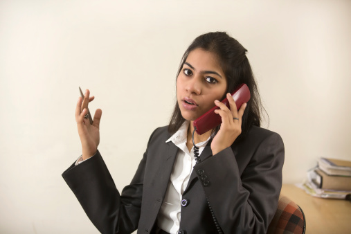 Happy and cheerful Indian Businesswoman talking on phone and negotiating with her client.