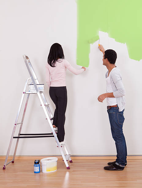 par de pintar la pared - home improvement couple painting real estate fotografías e imágenes de stock