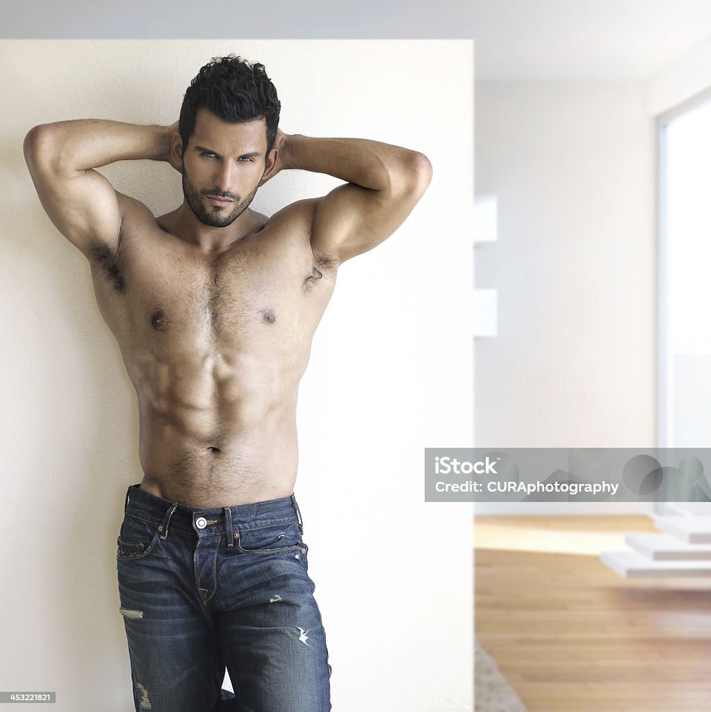 Sexy dude Sexy fashion portrait of a hot male model in stylish jeans with muscular body posing in modern setting Men Stock Photo