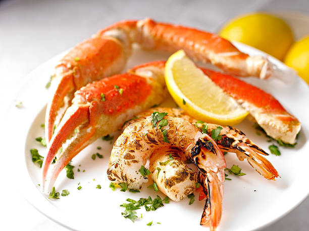 Plate full of King Crab Dinner King Crab Plate with Grilled Prawn. crab leg stock pictures, royalty-free photos & images