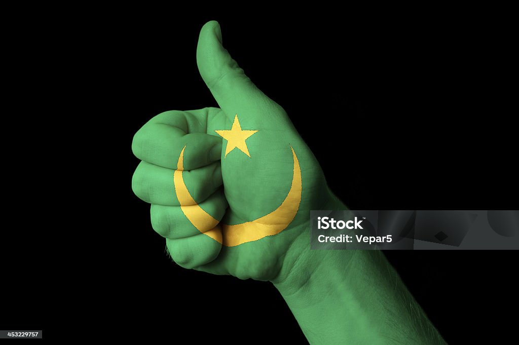 mauritania national flag thumb up gesture for excellence Hand with thumb up gesture in colored mauritania national flag as symbol of excellence, achievement, good, - for tourism and touristic advertising, positive political, cultural, social management of country Achievement Stock Photo