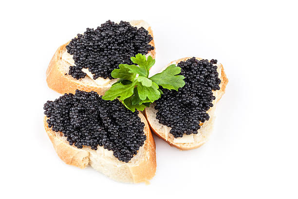 istock Small sandwiches with black caviar isolated on white background 453232151