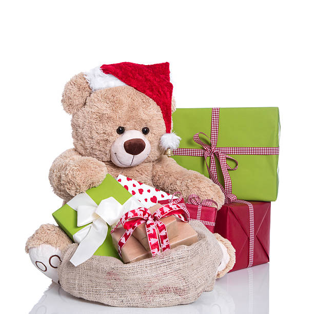 istock Cuddly teddy bear wearing Christmas hat and gift boxes. 453238155