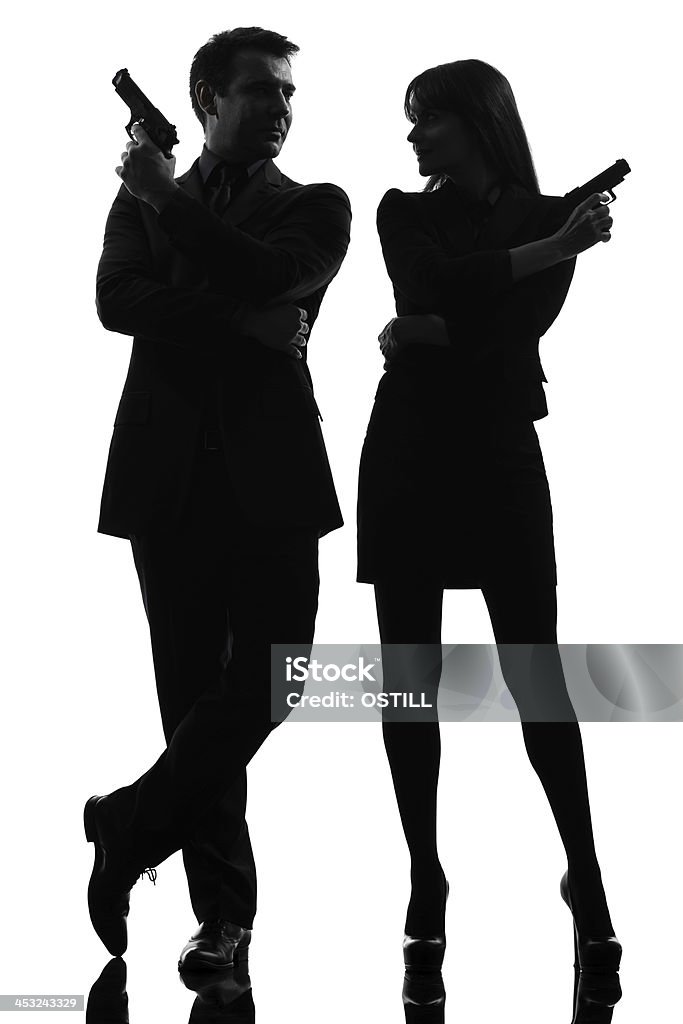 Silhouette of detective couple holding guns one caucasian man detective secret agent criminal with gun in silhouette studio on white background Spy Stock Photo