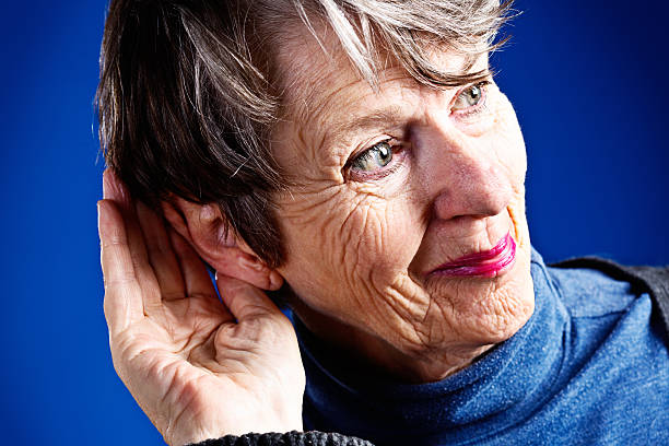 istock Deaf woman smiles delightedly, hand behind ear, at hearing something 453244101