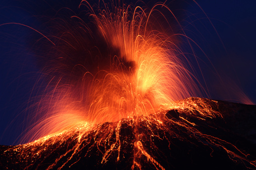 Volcanic crater exploding with strombolian eruption in the night