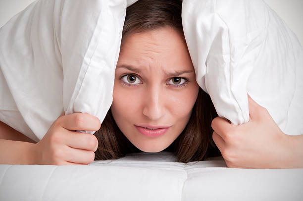 istock Woman hiding under pillow upon waking up 453253687