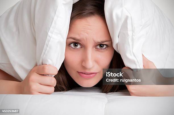 Woman Hiding Under Pillow Upon Waking Up Stock Photo - Download Image Now - Adult, Adults Only, Alarm Clock