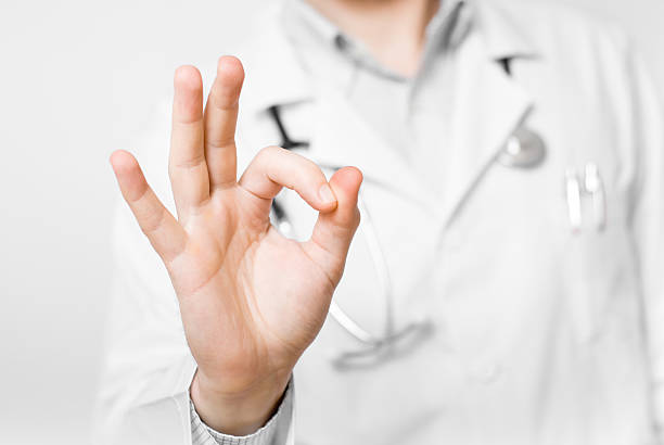 istock Young doctor with heart shaped hands isolated on white background 453255469