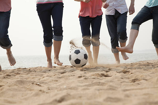 istock Young Friends Playing Soccer on the Beach 453256071