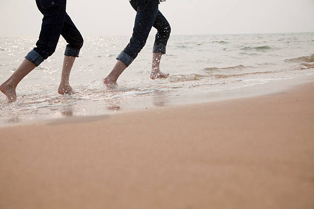 istock Young Couple Running in the Waves 453256121