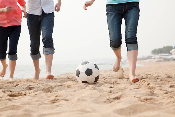 istock Young Friends Playing Soccer on the Beach 453256237