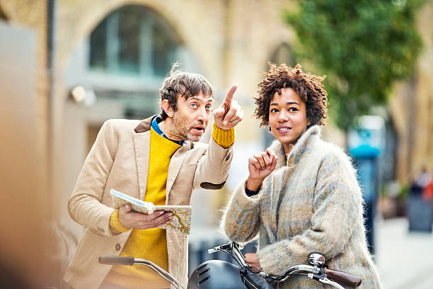 two cyclists looking for the right way with city map stock photo