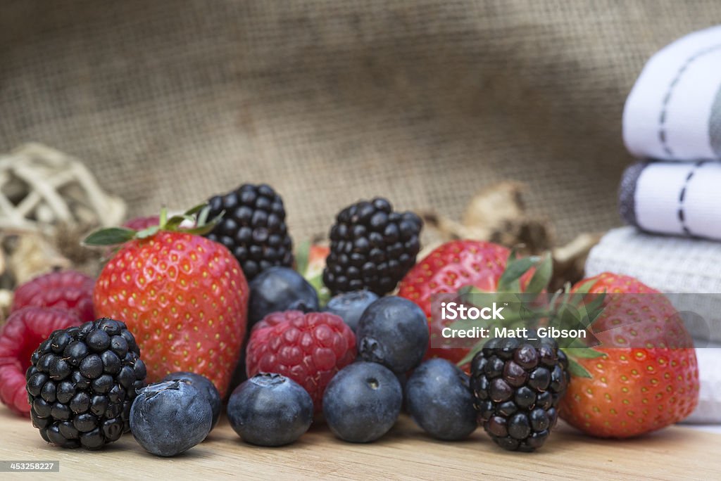 Fresh Summer berries in rustic kitchen setting Berry Fruit Stock Photo