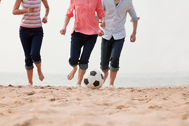istock Young Friends Playing Soccer on the Beach 453258891