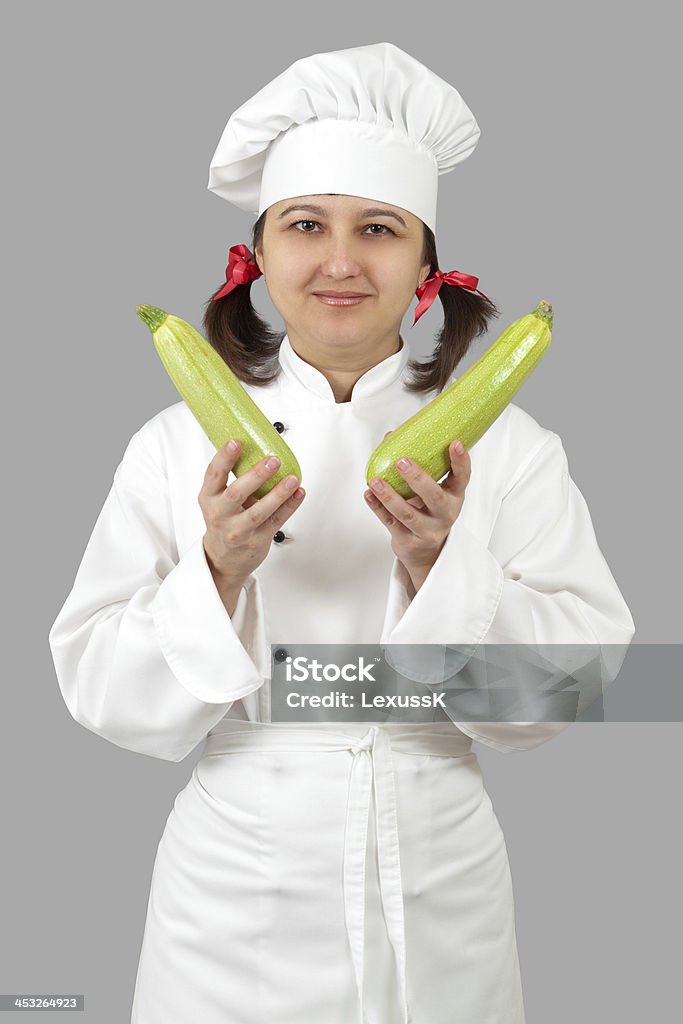 Femme de cuisson des légumes marrows Vert ranger - Photo de Adulte libre de droits