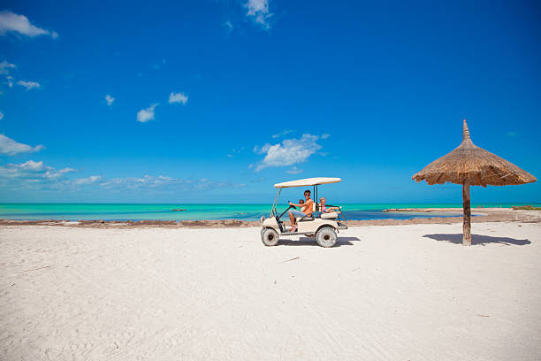 istock Dad with his daughters driving golf cart at tropical beach 453274879