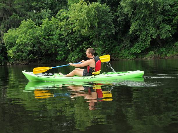 istock Young man kayaking on calm water 453276317