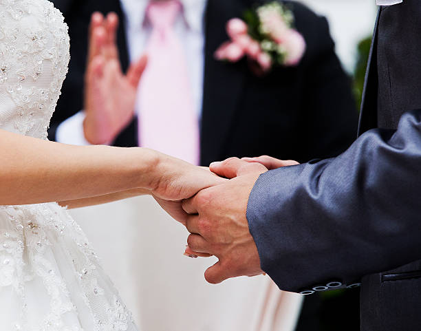 istock Bride and groom holding hands in wedding celemony 453282741