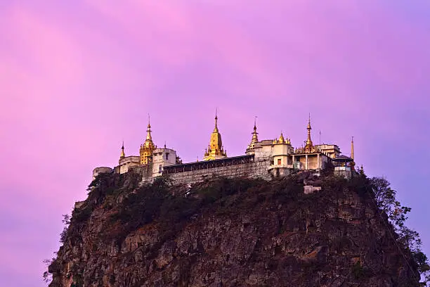 Taungkalat monastery and Mount Popa view at sunrise, Myanmar. Famous mount Popa is a volcano 1518 m. above sea level, and located in central Myanmar about 50 km southeast of Bagan in the Pegu Range.