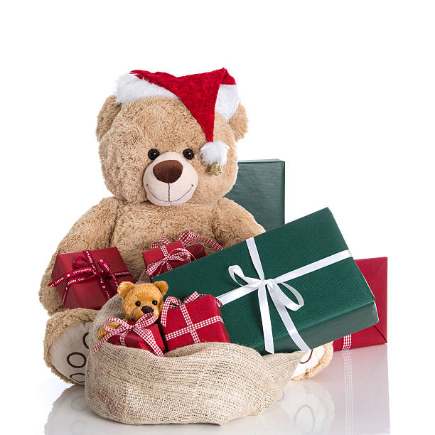 istock Teddy bear wearing Christmas hat with gifts isolated on white 453298741