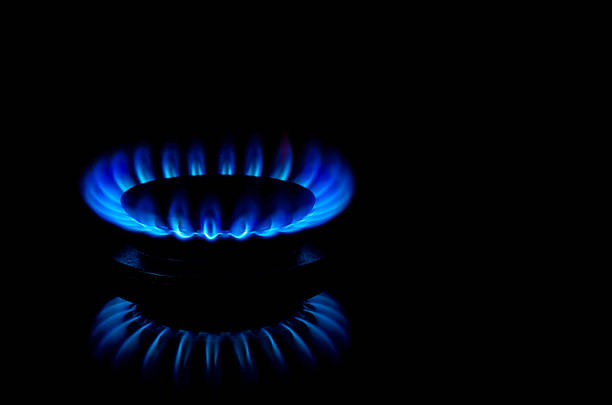 Blue flames from burner Blue  flames from gas stove burner. Closeup shot of blue flames from a kitchen gas range. burner stove top stock pictures, royalty-free photos & images