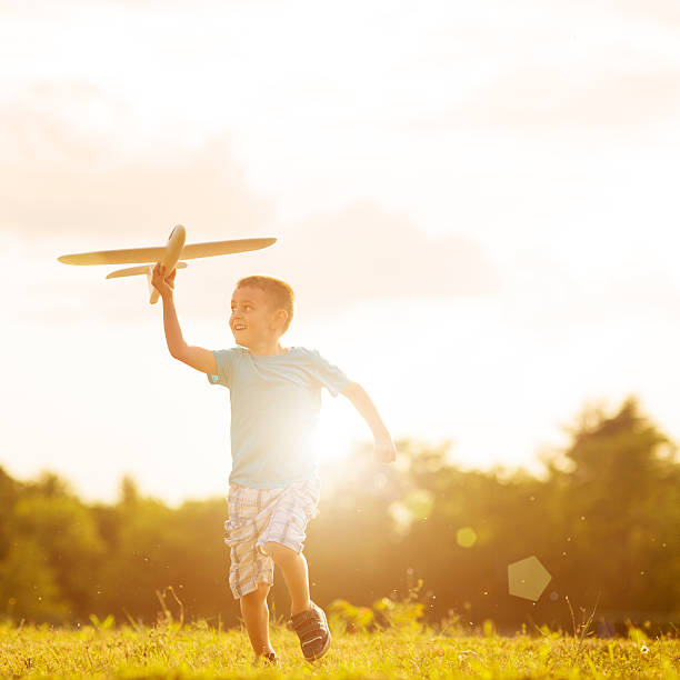 istock Young boy playing with toy airplane outside 453304333