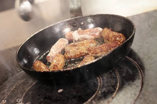 istock sausages cooking in frying pan 453304561