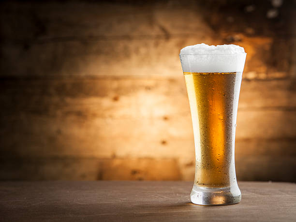 istock Glass of cold beer with foam on table 453304853