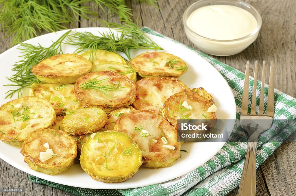 Fried zucchini with dill and garlic Fried zucchini with dill and garlic on wooden table Appetizer Stock Photo