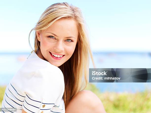 Woman Smiling With Grass And Water Blurred Background Stock Photo - Download Image Now