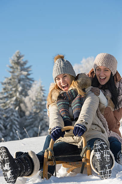 Rindo adolescentes trenó downhill no inverno - foto de acervo