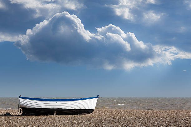 Modern wooden painted fishing boat on pebble beach by North Sea in Aldeburgh Suffolk on East coast of England
