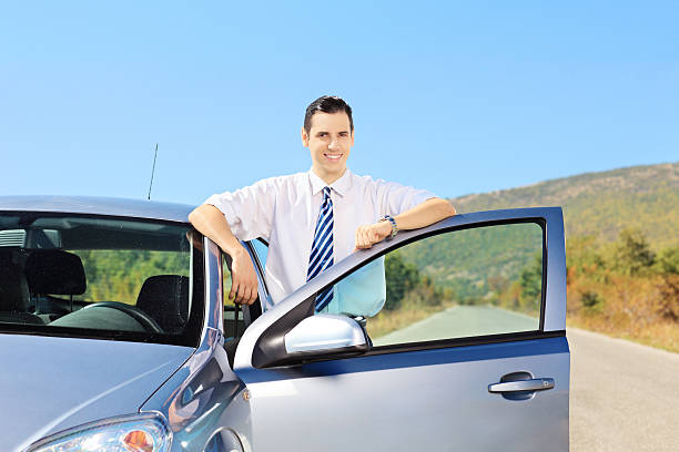 istock Smiling young male with tie posing next to his car 453309869
