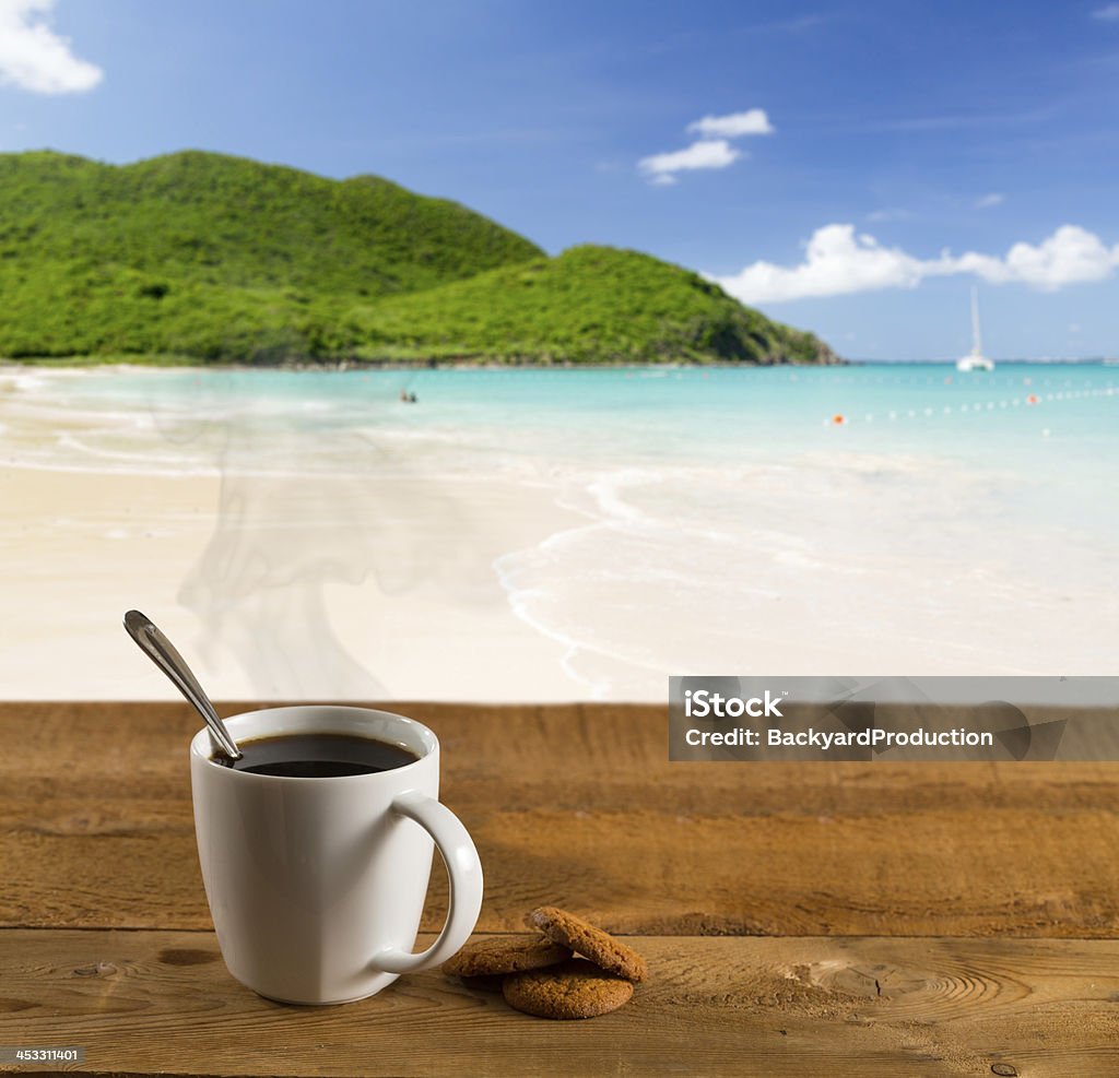 Morning cup of coffee on caribbean beach Morning cup of coffee on a wooden picnic table on Anse Marcel beach on St Martin in Caribbean in idyllic dreamlike location Beach Stock Photo