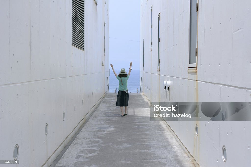 Mulher em um caminho em direção ao mar. - Foto de stock de Vista Traseira royalty-free