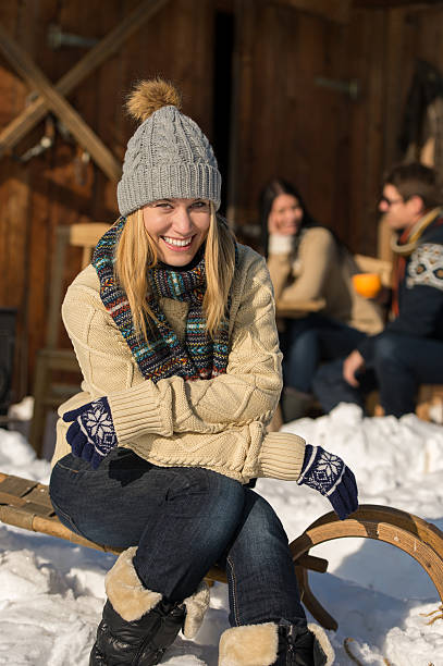 istock Young woman sitting winter snow sledge cottage 453387907