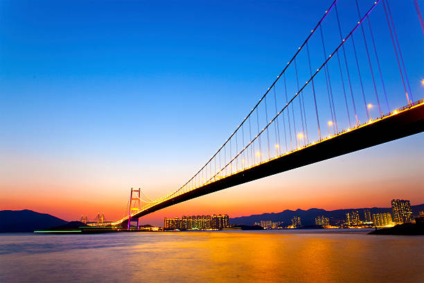 モダンな橋、街に沈む夕日 - suspension bridge 写真 ストックフォトと画像