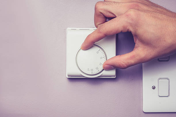 Hand turning dial on thermostat