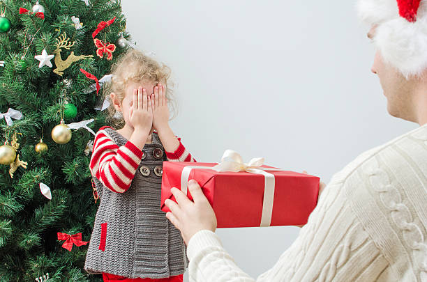 istock Father surprising little girl with christmas gift 453425135