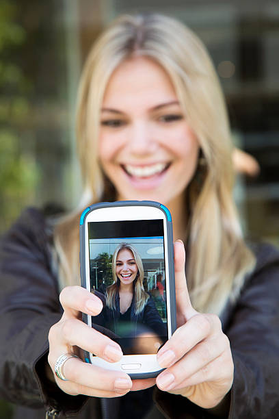 istock Blonde Female Taking Selfie on Cell Phone 453427493