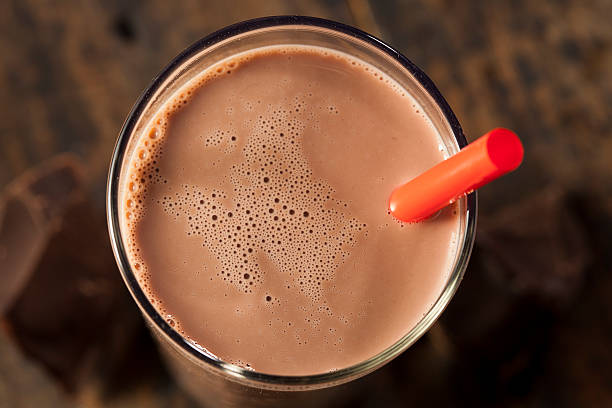 Chocolate milk on a glass with red straw Refreshing Delicious Chocolate Milk with Real Cocoa chocolate shake stock pictures, royalty-free photos & images