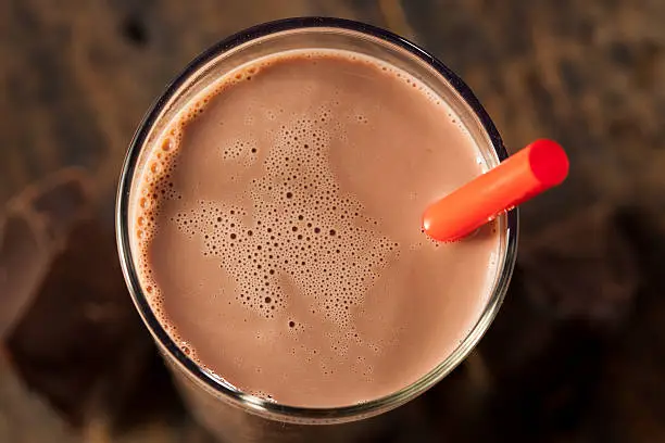 Photo of Chocolate milk on a glass with red straw