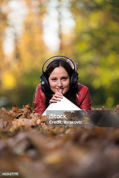 Sorridente Femmina Ascoltando Musica Autunno - Fotografie stock e altre immagini di Abbigliamento casual - Abbigliamento casual, Ambientazione esterna, Arte, Cultura e Spettacolo