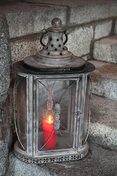 istock Old metal outdoor lamp with red burning candle 453428921