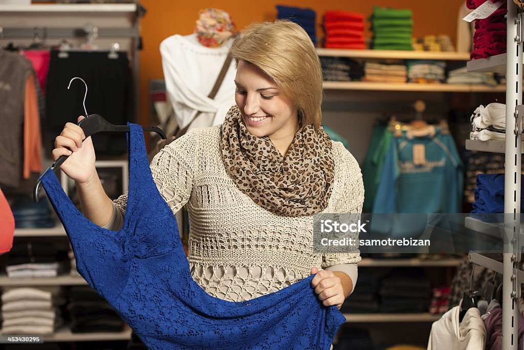 Young woman fitting a dress Young woman fitting a dress looking herself in a mirror Adult Stock Photo