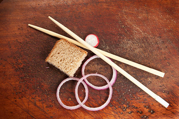 Hand holding chopsticks, isolated on white background.