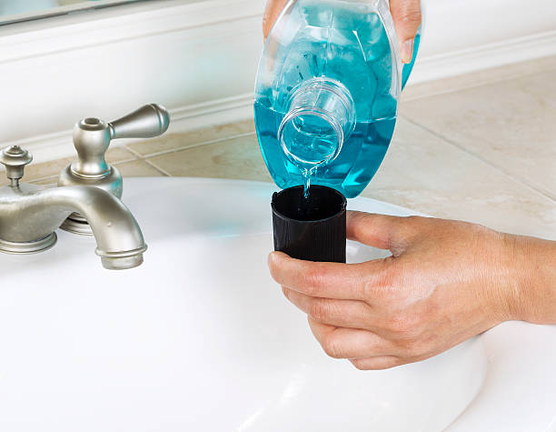 Pouring Mouth Washing into Cap stock photo