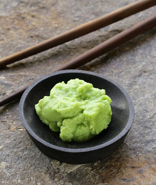 A little bowl with Japanese wasabi and chopsticks wasabi mustard sauce for Japanese food wasabi sauce stock pictures, royalty-free photos & images