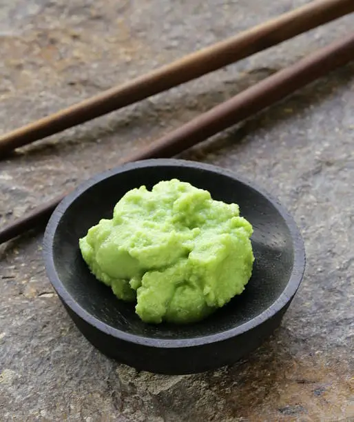 Photo of A little bowl with Japanese wasabi and chopsticks